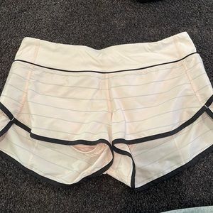 LuluLemon light pink shorts, with grey stripes and black trim.